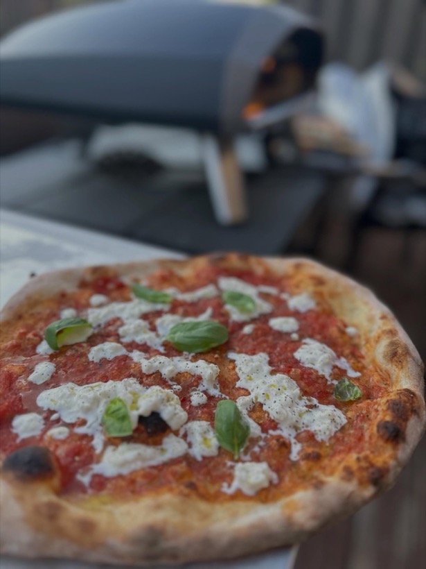 Margherita pizza with fresh mozzarella beside the live-fire oven